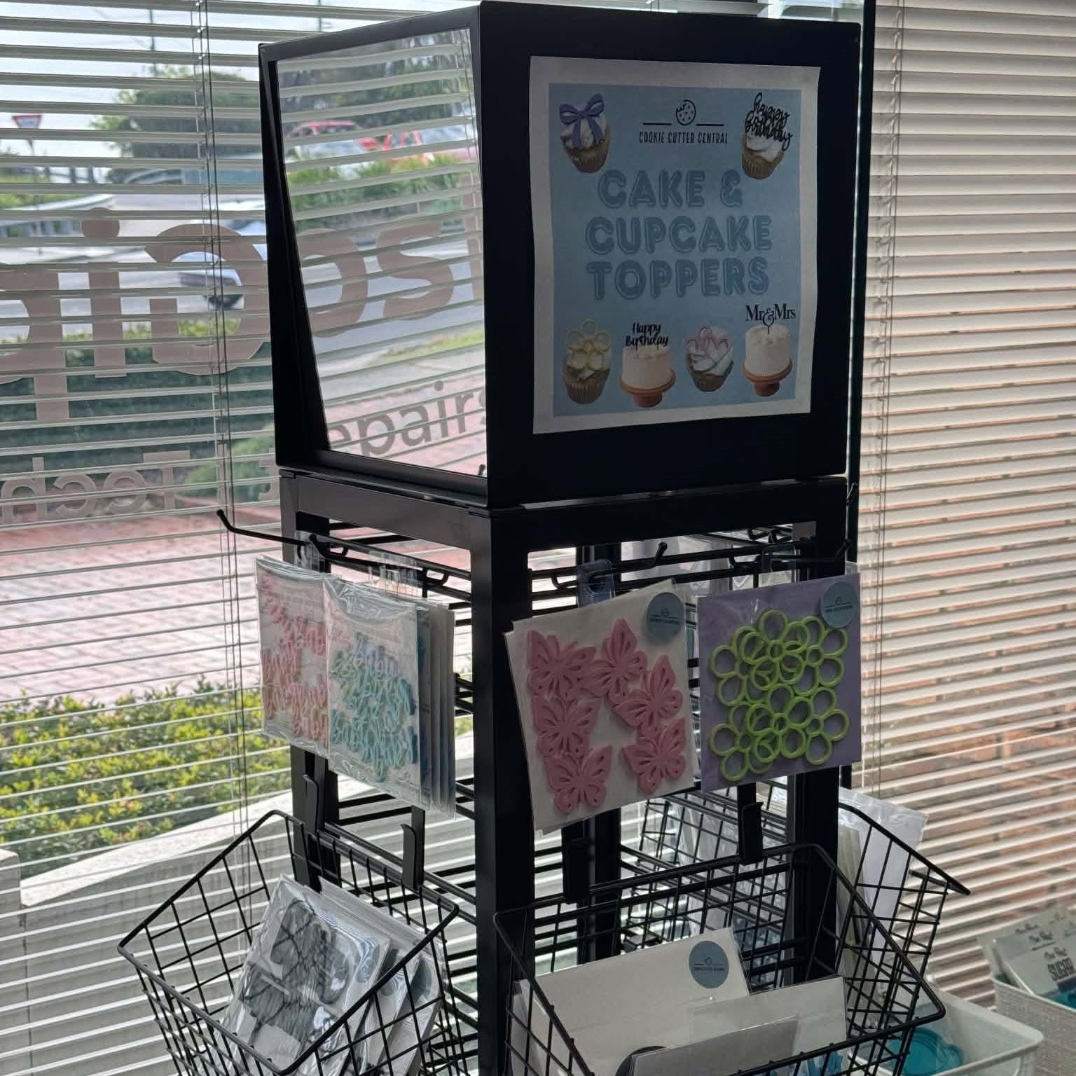 Cake and cupcake topper display stand beside the shop window